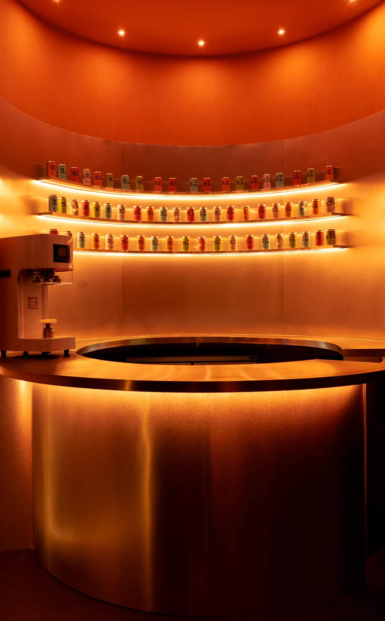 Barra circular metálica de Bar Latosa con iluminación cálida.
